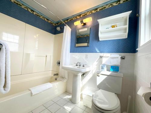 a bathroom with a white toilet and a sink and a tub at Winstead Beach Resort in Harwich Port