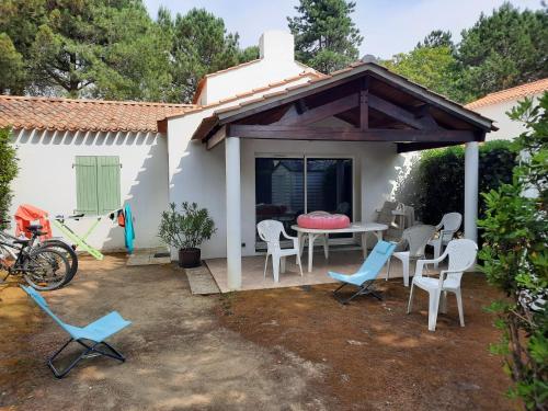 un patio avec une table et des chaises dans une cour dans l'établissement Victoria 204, à Saint-Jean-de-Monts