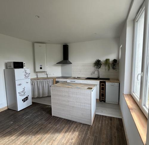 une cuisine avec un réfrigérateur blanc et un comptoir dans l'établissement TY GWEN Appart1, à Châteaulin