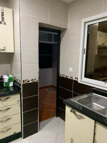 una piccola cucina con lavandino e specchio di Apartamentos Palace Rif Al Hoceima ad Al-Ḥoseyma