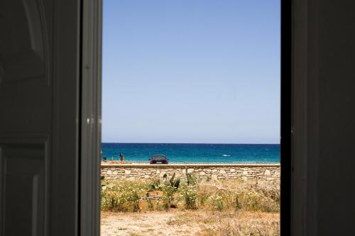 a view of the beach from a window at Pink Sand Sea Apartment in Adelianos Kampos