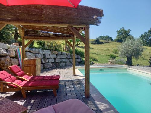 a pool with a gazebo and chairs and a red umbrella at Un parfum de Thaïlande, ressourcement et massages in Curemonte