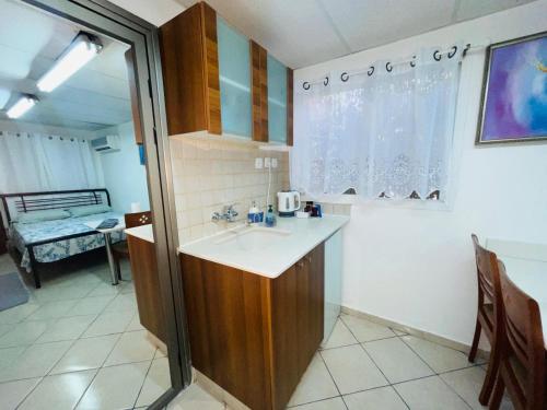 a small kitchen with a sink and a table at Eilat Beach House in Eilat