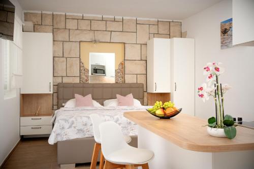 een slaapkamer met een bed en een tafel met stoelen bij Villa Rajski Dvor in Bol