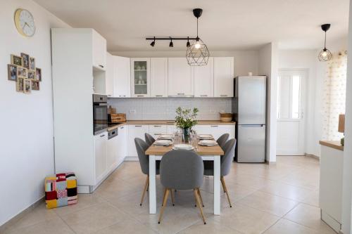 a kitchen with a table and chairs and a refrigerator at Holiday house Mila in Postira