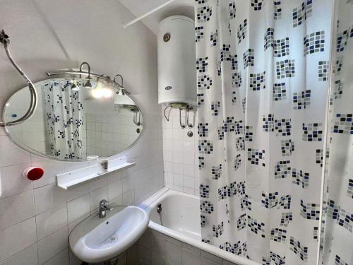 uma casa de banho com um lavatório e uma cortina de chuveiro em Melanie- City Centre Apartment em Herceg Novi
