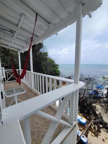 een witte veranda met een hangmat op het strand bij Mangrove Bay Hotel in Buenavista