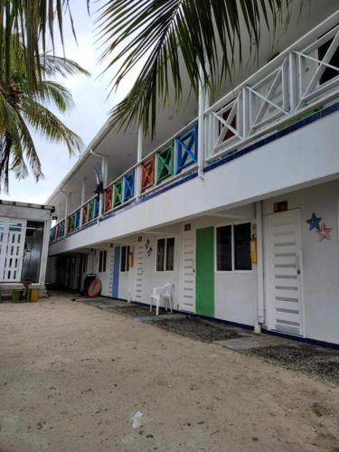 - un bâtiment blanc avec un balcon et un palmier dans l'établissement Mangrove Bay Hotel, à Buenavista