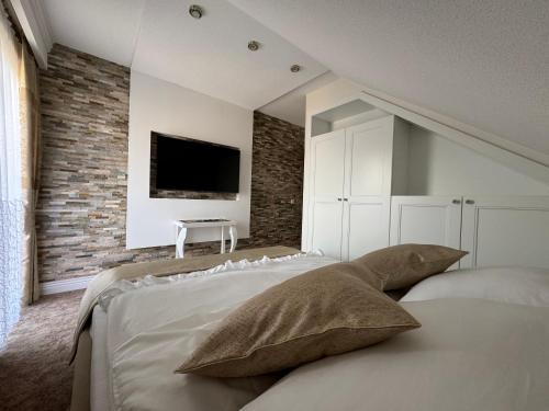 een slaapkamer met een bed en een tv aan de muur bij Domilo in Mżyki