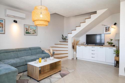 a living room with a couch and a tv at Holiday house Mila in Postira
