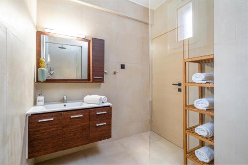ein Bad mit einem Waschbecken und einem Spiegel in der Unterkunft Villa Kalliopi ΙnCreteble Cretan Resindences Collection in Xerokampos