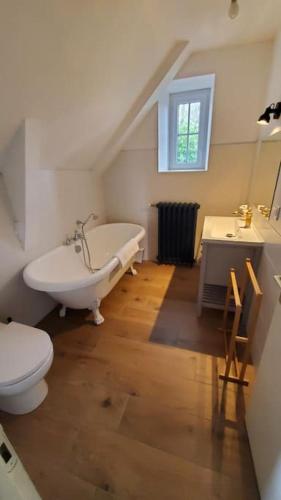 une salle de bain avec une baignoire, des toilettes et un lavabo dans l'établissement Le Couvent B, à Saint-Jean-Kerdaniel