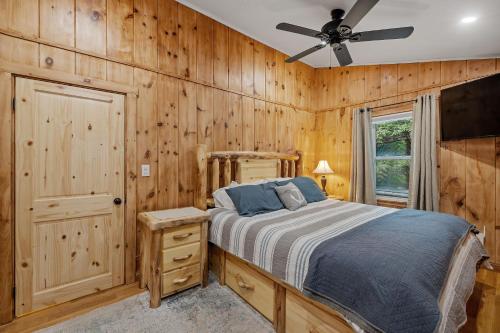 Schlafzimmer mit einem Bett und einem Deckenventilator in der Unterkunft 3BR Lakeside Oasis: Boat Dock + HOT TUB + Beach! in Center Harbor