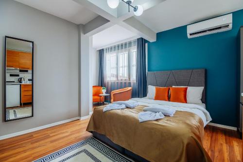 a bedroom with blue walls and a bed with orange pillows at Taksim Wonder Suites in Istanbul