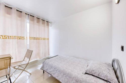 une chambre avec un lit, un bureau et une fenêtre dans l'établissement Studio douillet, à Sarcelles