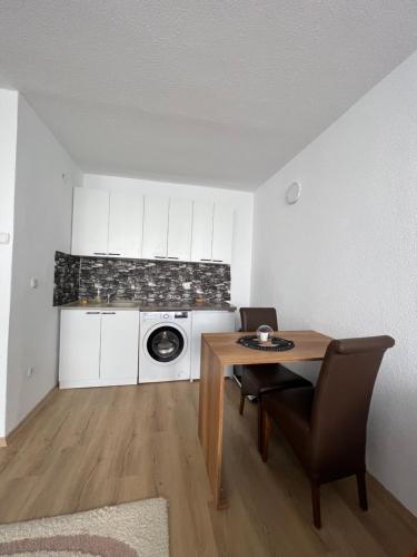 ein Wohnzimmer mit einem Tisch und einer Waschmaschine in der Unterkunft CozyApartment in Pristina