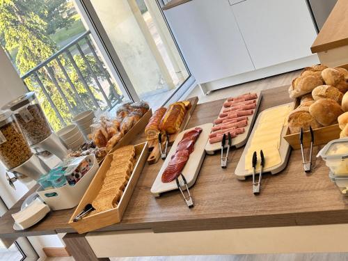 a table with different types of bread and meats at Marinha Garden Inn in Marinha Grande