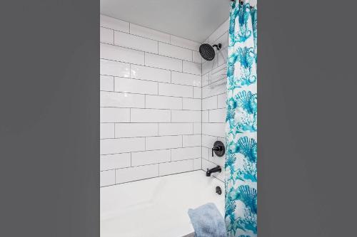 ein Badezimmer mit einer Dusche mit einem blauen Duschvorhang in der Unterkunft Kingston Arms 1st Fl Cottage in Sarasota