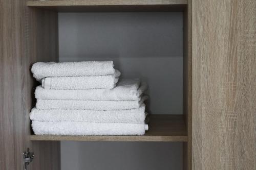 una pila de toallas en un estante del baño en Blue Sea Apartment, en Adelianos Kampos