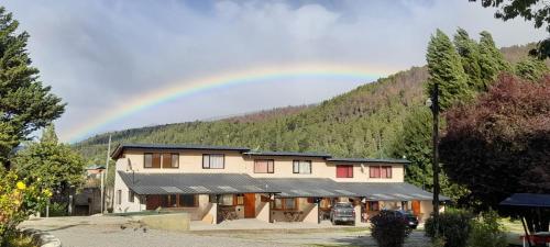 einen Regenbogen am Himmel über einem Gebäude in der Unterkunft Camping El Bolson in El Bolsón