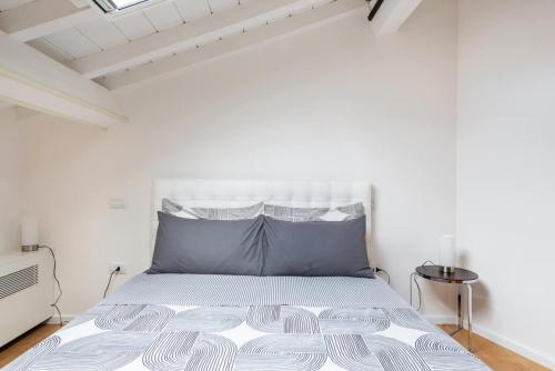 a white bedroom with a bed in a room at Residenza Palazzo Petrozzani in Mantova