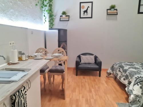 サン・セバスティアン・デ・ロス・レイエスにあるLoft con baño y cocina privadosのテーブル、椅子、ベッドが備わる客室です。