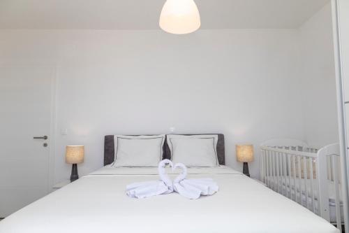 a white bed with two white bows on it at Holiday house Mila in Postira