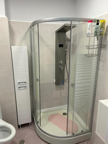 a glass shower in a bathroom with a toilet at Апартаменти Уют in Plovdiv