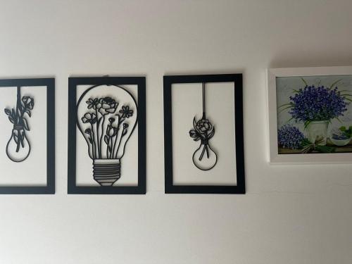 a group of four pictures on a wall with a light bulb at Lar Loudge Montanhes in Campos do Jordão