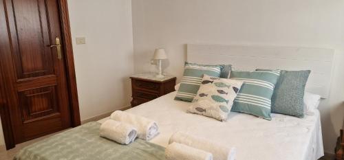 1 dormitorio con 1 cama con almohadas azules y blancas en Apartamento Raxobrisamar, en Raxó