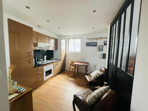 a kitchen and living room with a couch and a table at Appartement proche de la mer au Touquet in Le Touquet-Paris-Plage