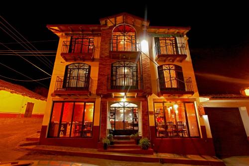 a tall building with windows and balconies at night at Hotel Real de la Sierra in Mazamitla