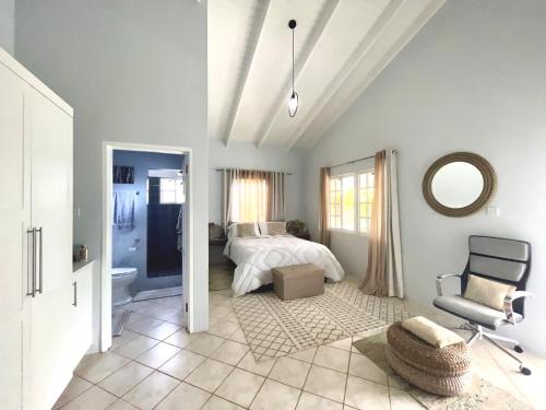 a bedroom with a bed and a chair at Villa Lu-Ja in Mount Cassell Land Settlement