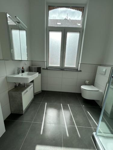een badkamer met een wastafel, een toilet en een raam bij Alte Schule 2 in Schauenburg