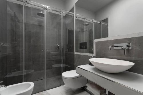 ein Bad mit einem WC, einem Waschbecken und einer Dusche in der Unterkunft UNYCA - Santa Croce Plaza in Florenz