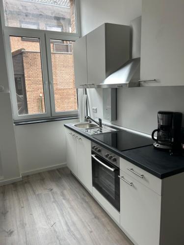 a kitchen with white cabinets and a stove top oven at Alte Schule 2 in Schauenburg