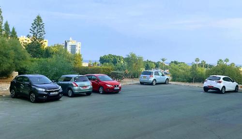 a group of cars parked in a parking lot at Modern apartment near McKenzie beach in Larnaka