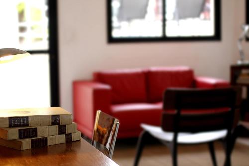 a living room with a red couch and a table at Hotel Germânia in Joinville