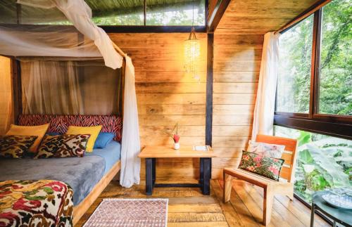 a bedroom with a bed and a table in a room at La Shamana - Ecological Concept in Jungle in Cahuita