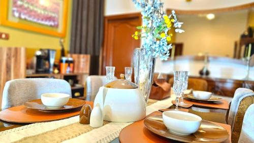 a table with plates and bowls and a kettle on it at شقة دوبلكس مكيفة مفروشة بالكامل فرش جديد بالمنصورة in Mansoura