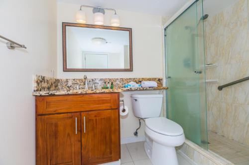 La salle de bains est pourvue de toilettes, d'une douche et d'un miroir. dans l'établissement Ilikai Tower 1027, à Honolulu