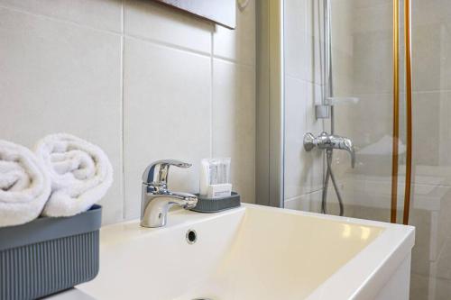 a bathroom with a sink and a shower with towels at Azure Haven in Willemstad