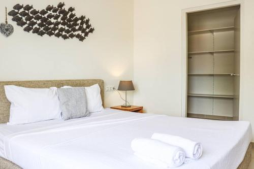 a bedroom with a white bed with towels on it at Azure Haven in Willemstad