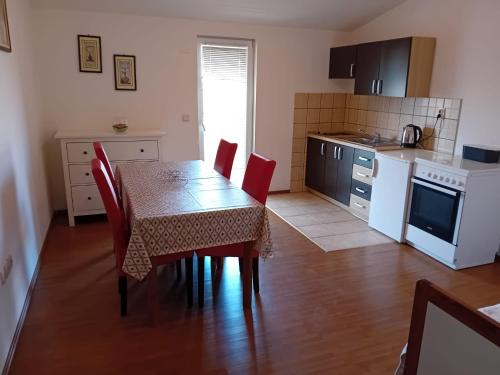 a kitchen with a table and red chairs in a room at Apartman Peace 3 in Međugorje