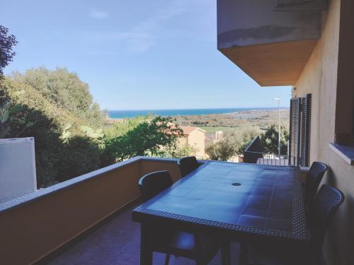 a blue table and chairs on a balcony at Domus DELEDDA 'CONCHIGLIA' in Posada