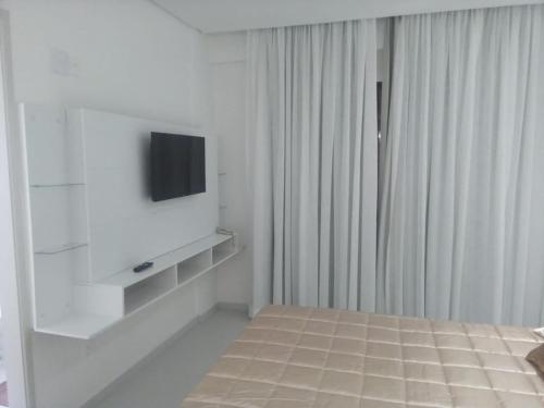 a white room with a television on a wall at LEON MARIA HOSPEDAGENS - Smart Flat Hotel e Residence in Mogi das Cruzes