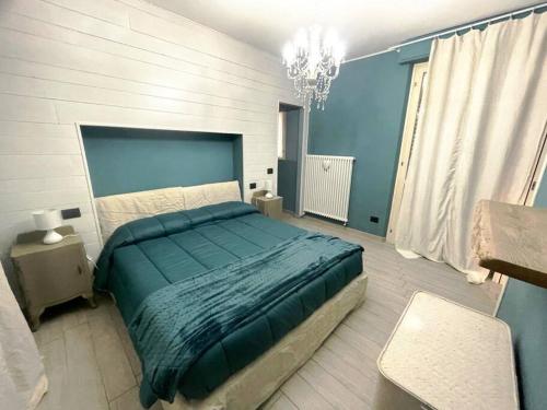 1 dormitorio con cama y lámpara de araña en Casa Story 2 è un piccolo gioiello en Asti