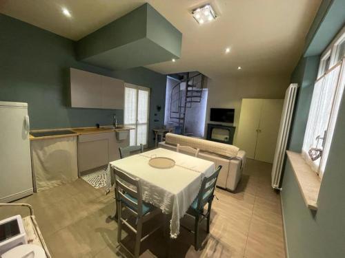 een keuken en een woonkamer met een tafel en een bank bij Casa Story 2 è un piccolo gioiello in Asti