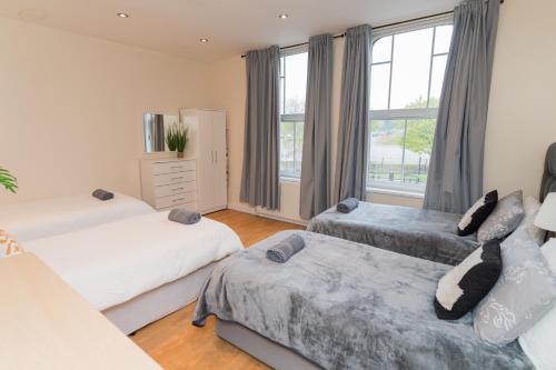 a bedroom with two beds and a window at Aston Apartments-4 11 Lichfield Road Birmingham B6 5RW in Birmingham