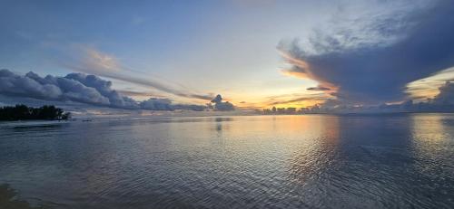 a sunset over a large body of water at MOOREA - Tropical Nest in Hauru